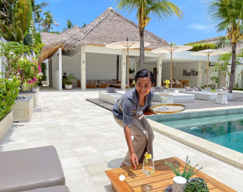 Hostess serving drinks by the pool at Bali Droom Villas